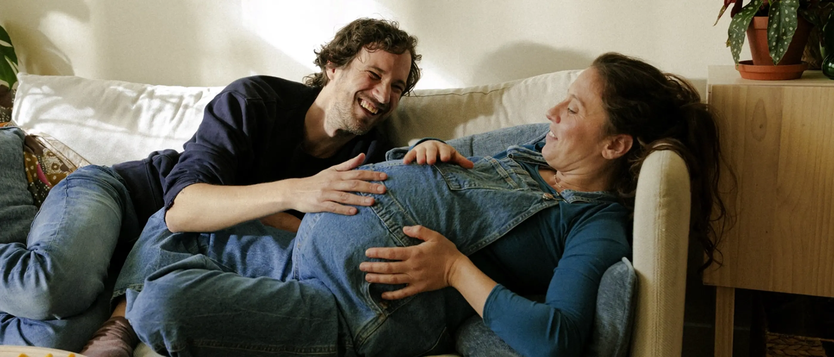 En gravid kvinna vilar sig i soffan.