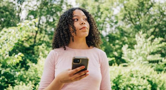 Kvinna håller i mobil utomhus