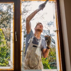 Hanterkare målar fönsterkarm.