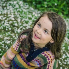 flicka i blomsterhav.