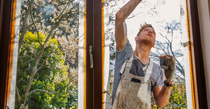 Hantverkare målar fönsterkarm.