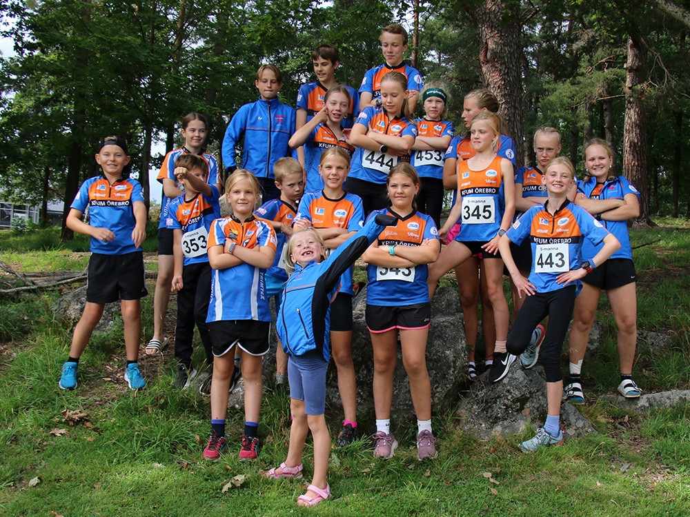 Barn tränar orientering i skogen.