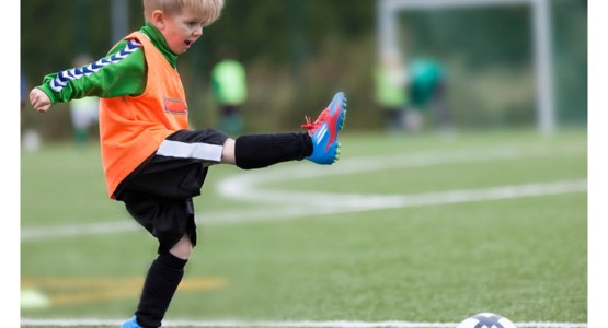 Liten pojke spelar fotboll