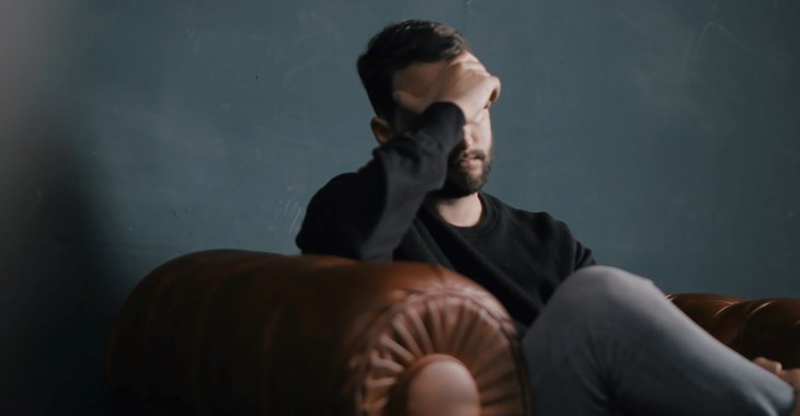 Kille sitter i en soffa