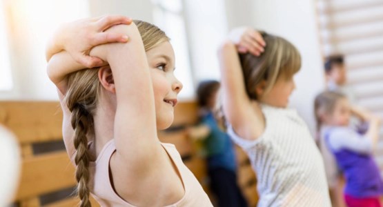 Barn stretchar i en gymnastiksal.