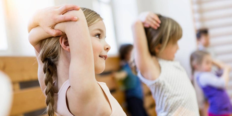 Barn stretchar i gymnatiksal.