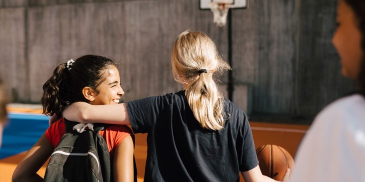 Två tjejer spelar basket.