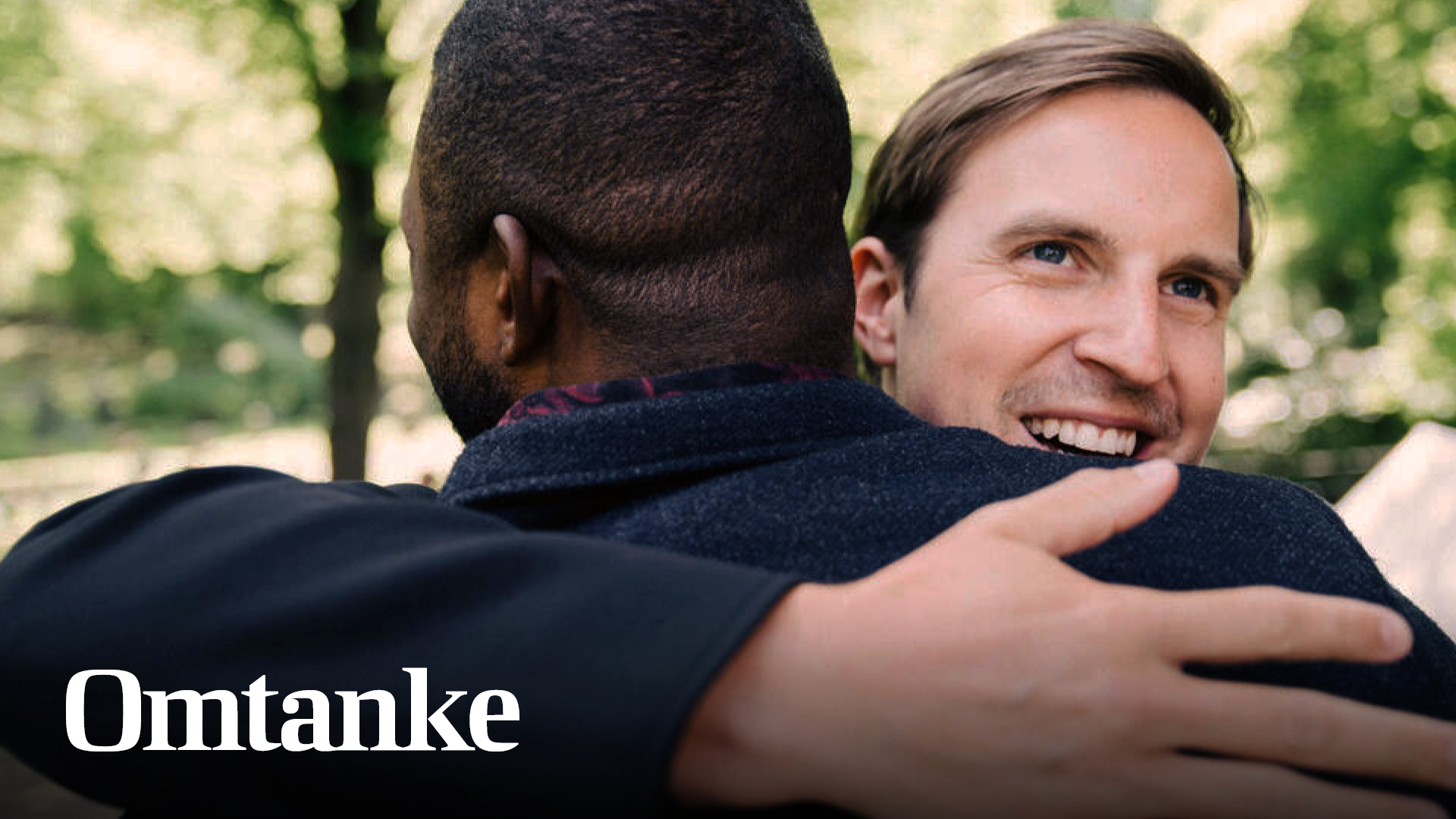 Två män omfamnar varandra och Omtanke står skrivet intill männen.