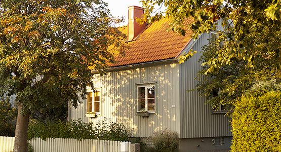 Villa i lummig trädgård och kvällssol.