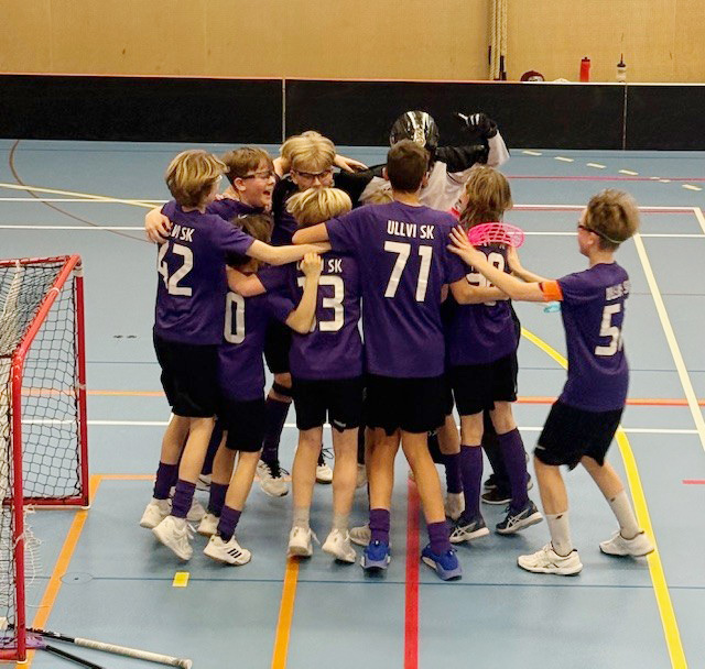 Barn spelar innebandy.