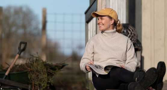 Kvinna sitter utomhus i solen