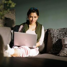 Kvinna vid dator tittar hur mycket hon får i skatteåterbäring