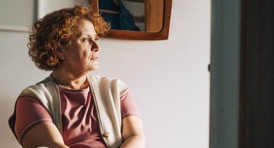 Kvinna tittar ut genom fönstret. 