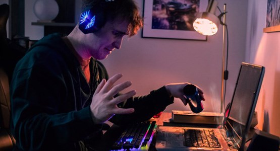 En kille spiller dricka över sin dator mitt i ett spel.