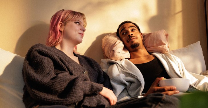 Två sambos sitter i soffan och diskuterar.