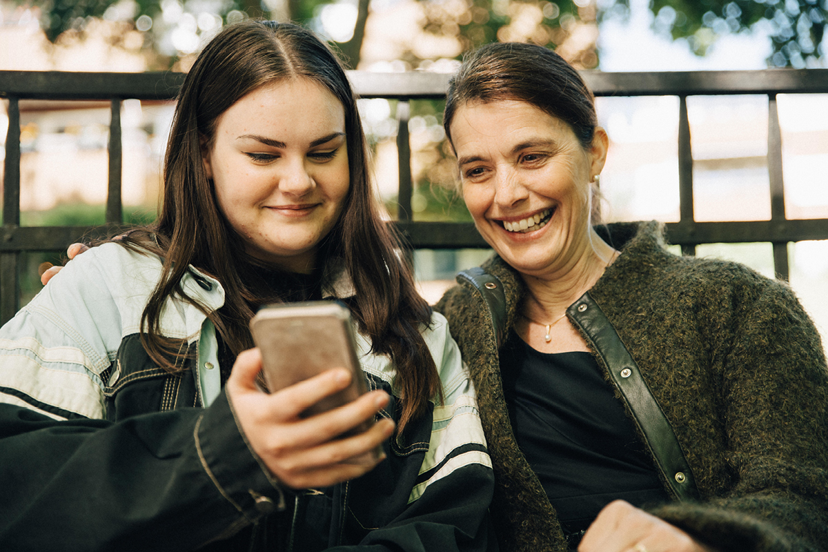 Två tjejer kollar i en mobil.