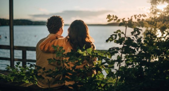 Par på bänk ser ut över havet.
