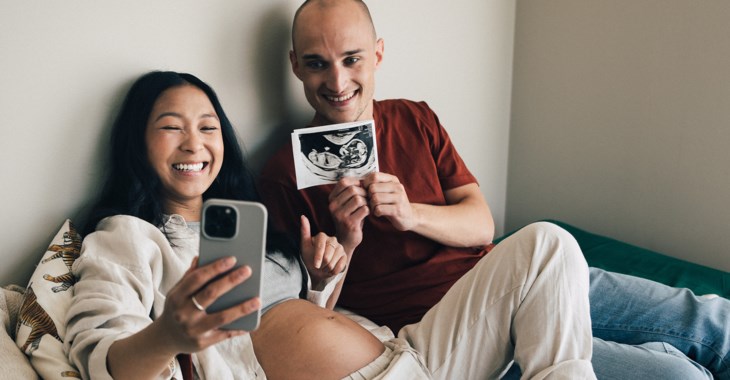 En blivande mamma och pappa kollar på ultraljudsbilder.