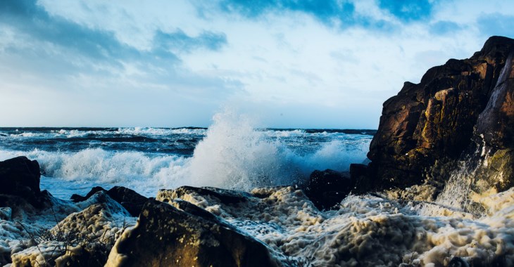 Höga vågor som slår in mot klippor.