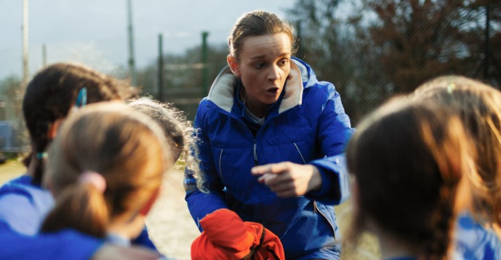Barn studsar boll på huvudet. 