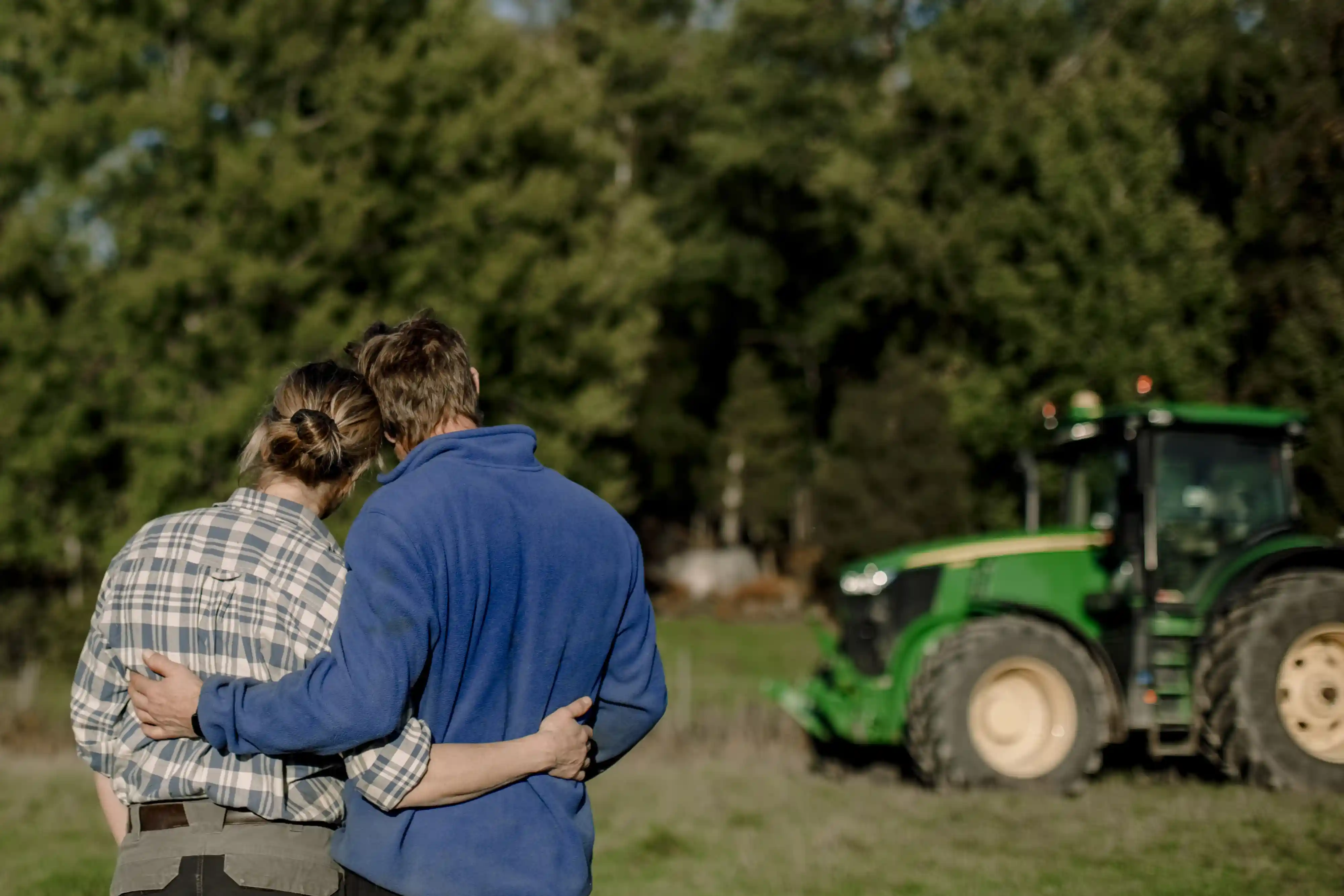 Par framför traktor, fotografi.
