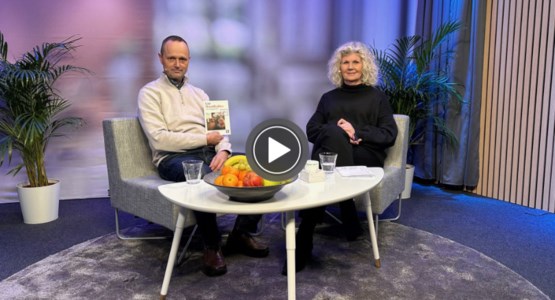 Två personer sitter i en studio och tittar in i kameran.