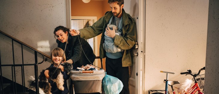 Familj med barnvagn och hund i trapphus