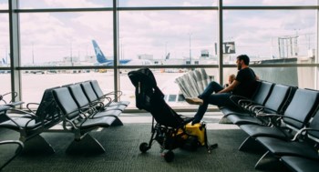En pappa med sitt barn sitter och väntar på en flygplats.