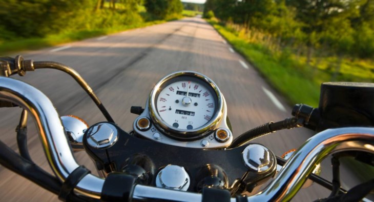 Instrumentpanelen på en motorcykel som åker längs en landsväg.