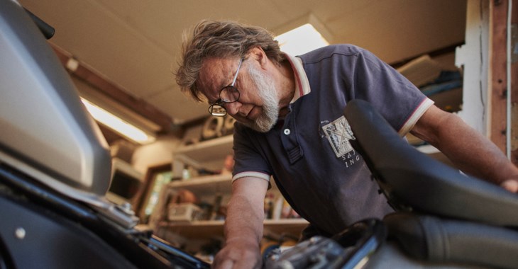 Äldre man arbetar i verkstad