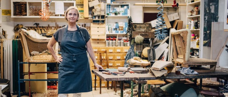 Kvinna med förkläde i textilateljé.