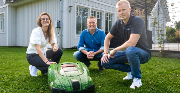Tre personer vid en robogräsklippare.