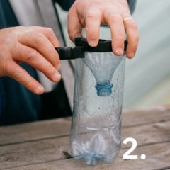 Händer som tejpar fast toppen av flaskan uppochner i botten.