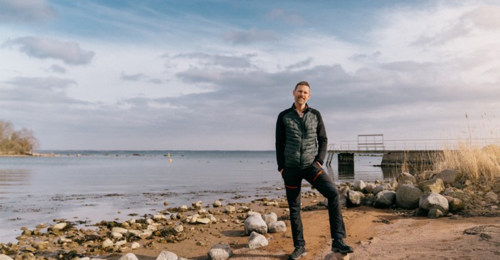 Simon Karlsson står på en strand med Kalmarsund bakom sig.