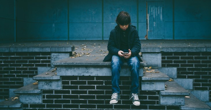 Pojke sitter på en trappa