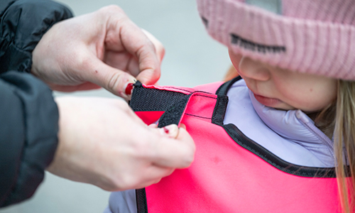 BAr med en reflexväst som har kardorre i axlarna