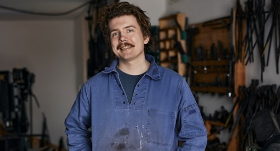 Man i arbetskläder i verkstad