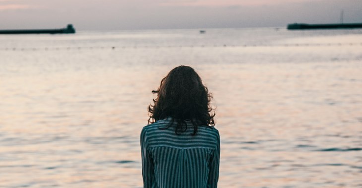 En kvinna tittar ut över havet.