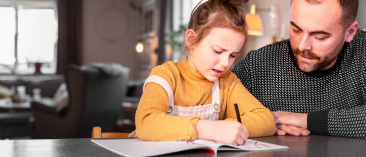 Pappa hjälper dotter med läxa.