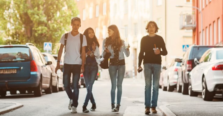 Glada ungdomar går på en gata