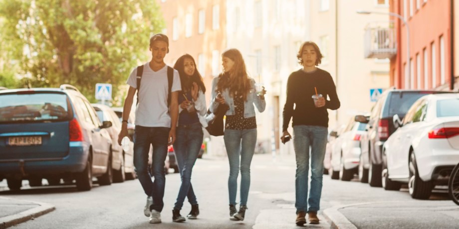 Glada ungdomar går på en gata