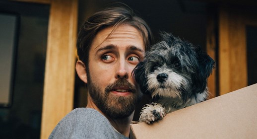 Ung kille kollar i sin mobil utomhus.