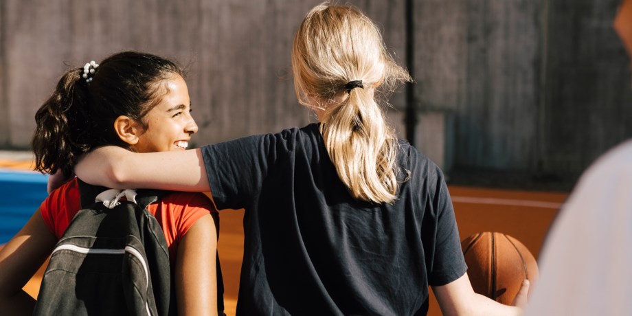 Två unga tjejer som spelar basket
