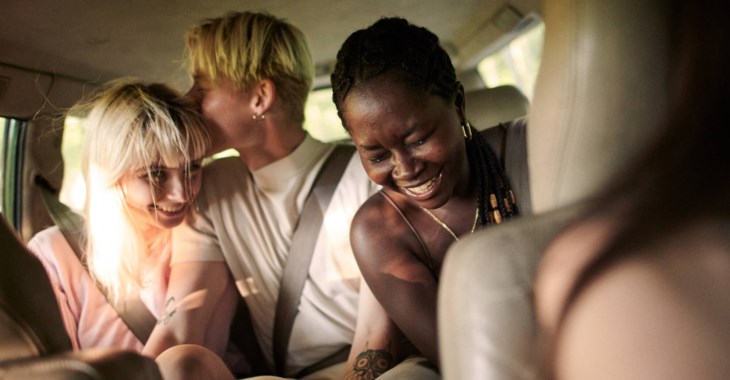 Undgomar som skrattar och har kul i ett bilbaksäte.