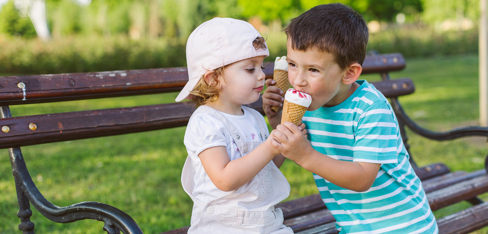 two children share an ice cream