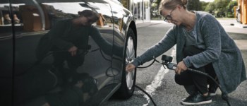 Kvinna kollar lufttryck på bil.