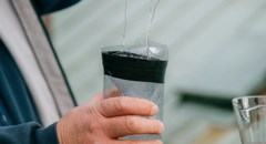 En man hänger upp en egengjord getingfälla 