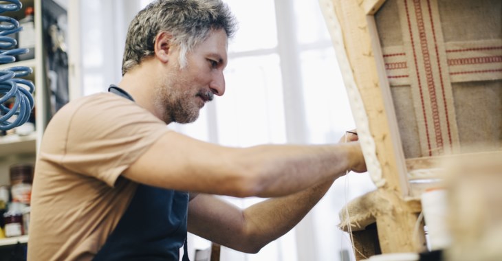 Man som klär om en möbel.