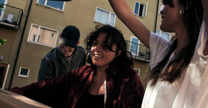 Personer som bär ut en flyttkartong ur en bil.