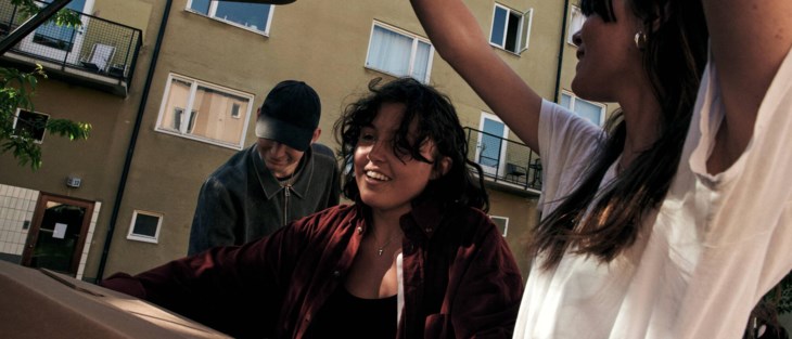 Ungdomar packar ut flyttlådor ur bil